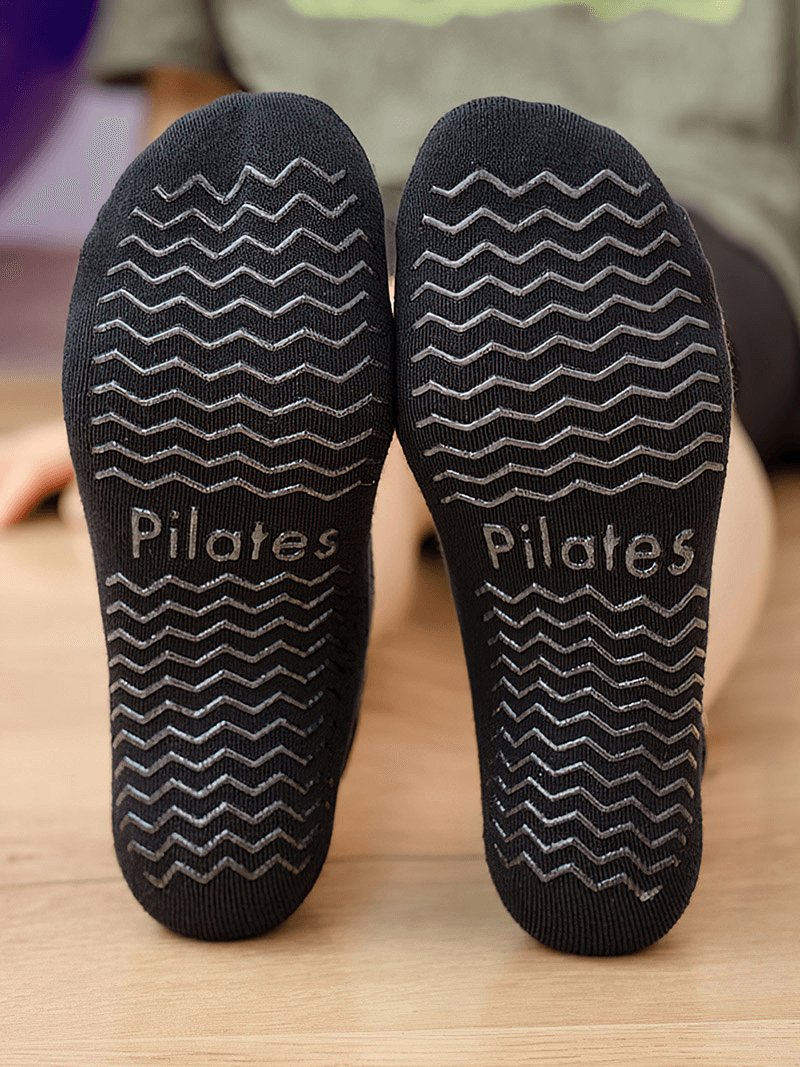 Close-up of black non-slip Pilates socks with grip pattern, perfect for yoga and dance, showcasing stability and comfort.
